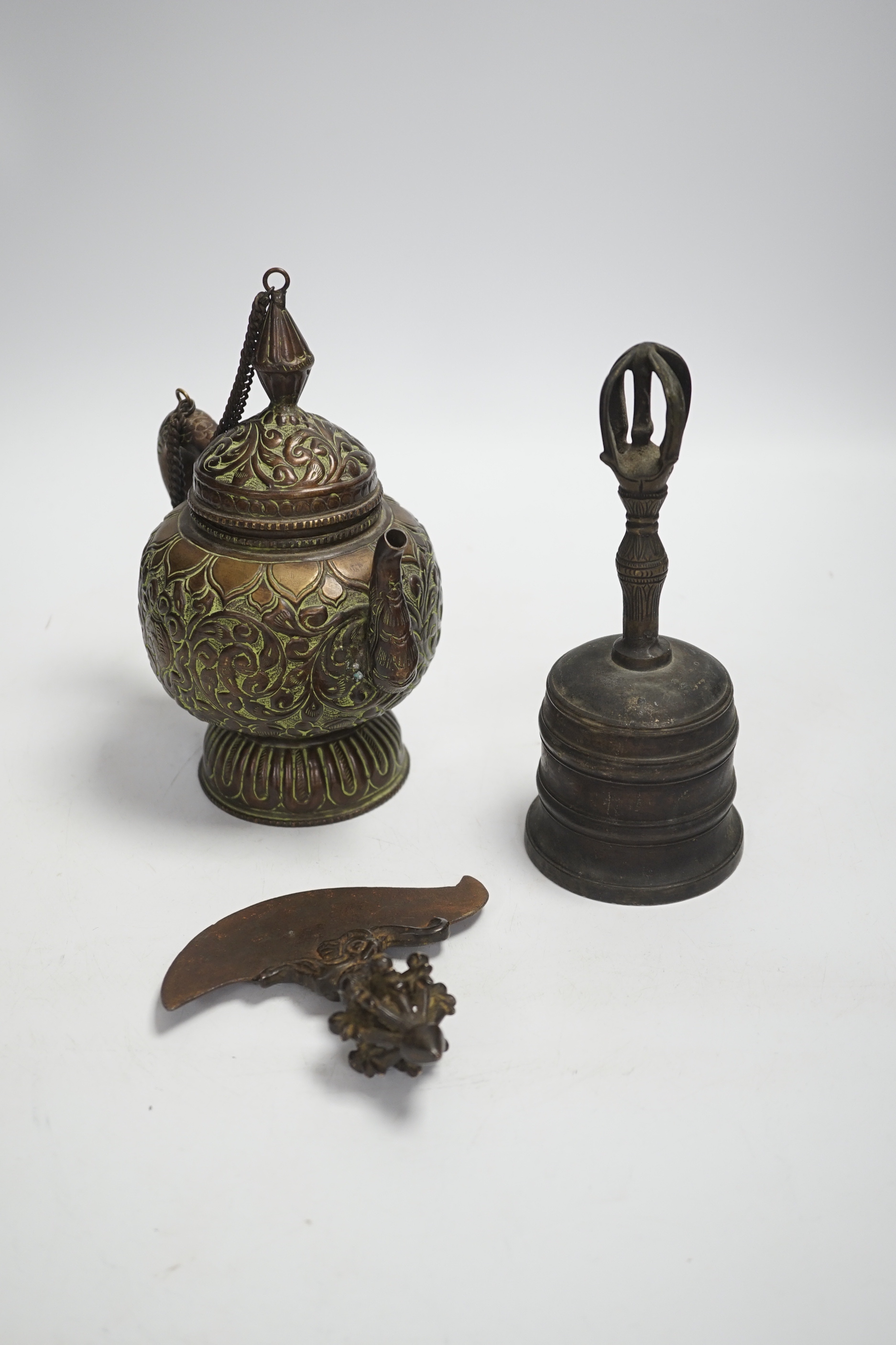 A Tibetan repousse teapot, a ghanta bell and a kartika chopper, tallest 19cm